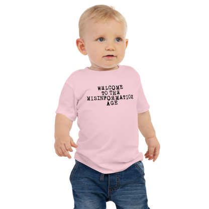 "Welcome to the misinformation age" printed on a pink baby jersey short sleeve tee worn by a male