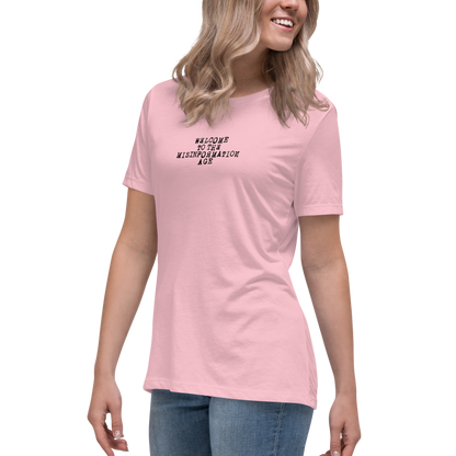 "Welcome to the misinformation age" printed on a pink women's relaxed t-shirt worn by a female