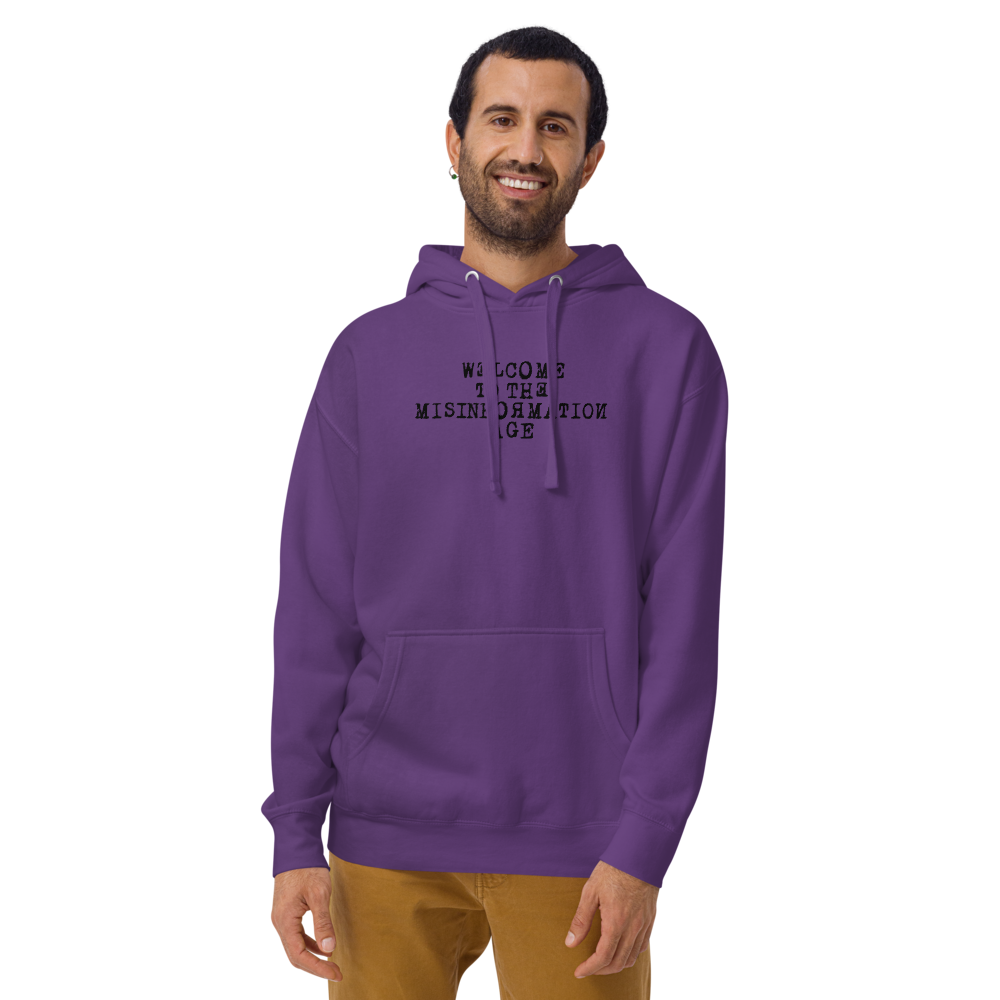 "Welcome to the misinformation age" printed on a purple warn by a male