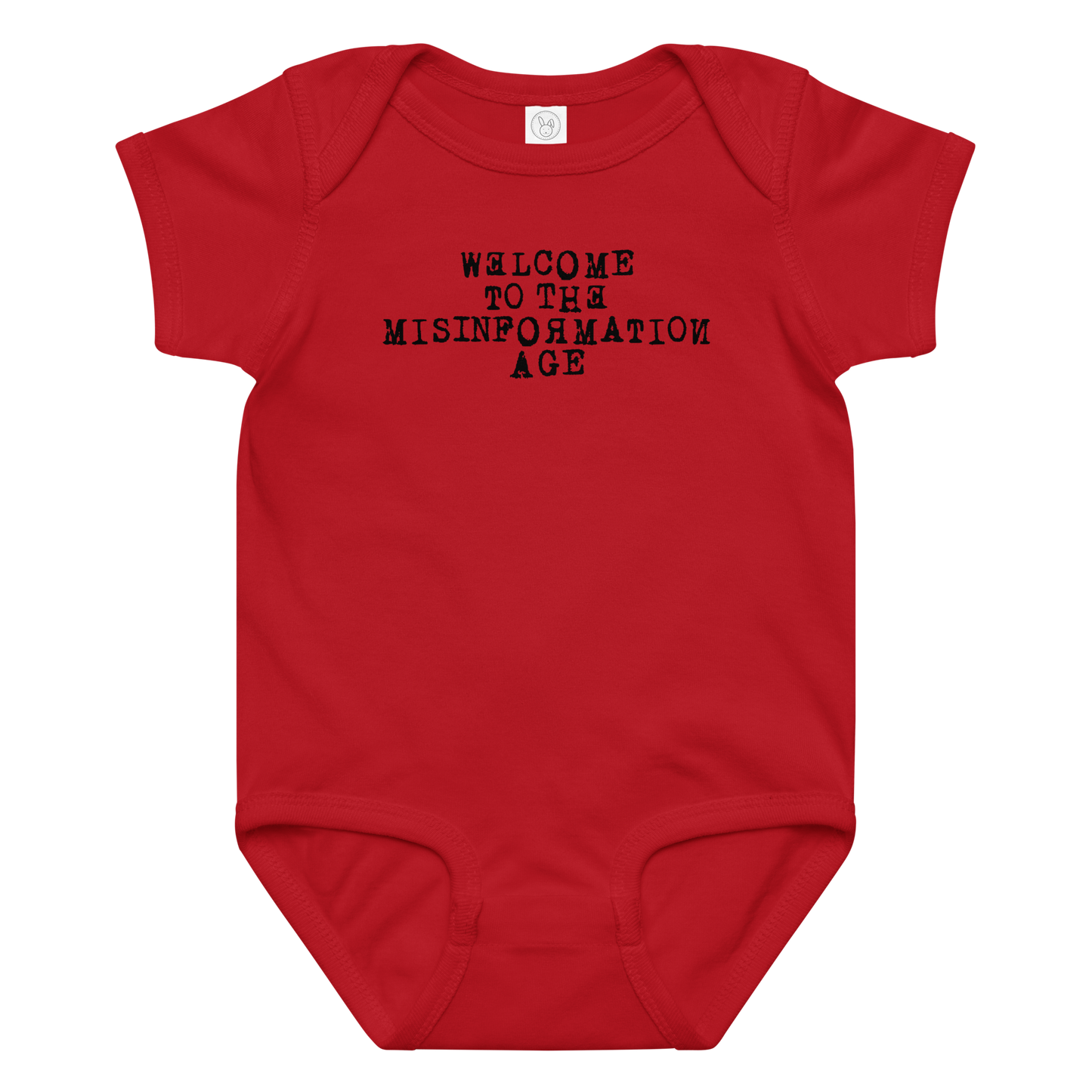 "Welcome to the misinformation age" printed on a red baby jersey bodysuit laying on a flat surface amongst other clothes