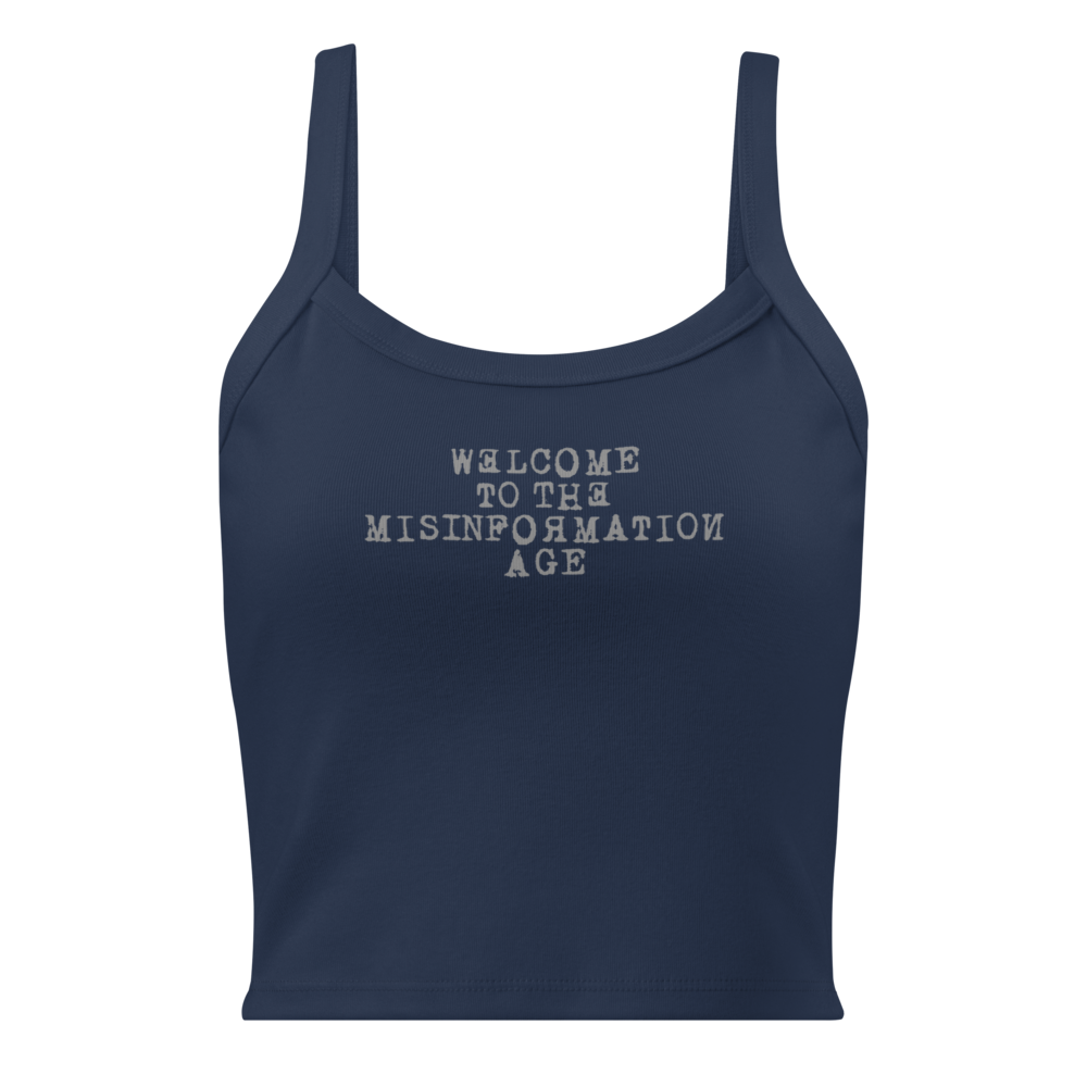 "Welcome to the misinformation age" printed on a solid navy blend women's micro-rib tanktop laying on a flat surface
