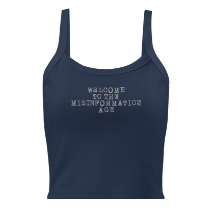 "Welcome to the misinformation age" printed on a solid navy blend women's micro-rib tanktop laying on a flat surface