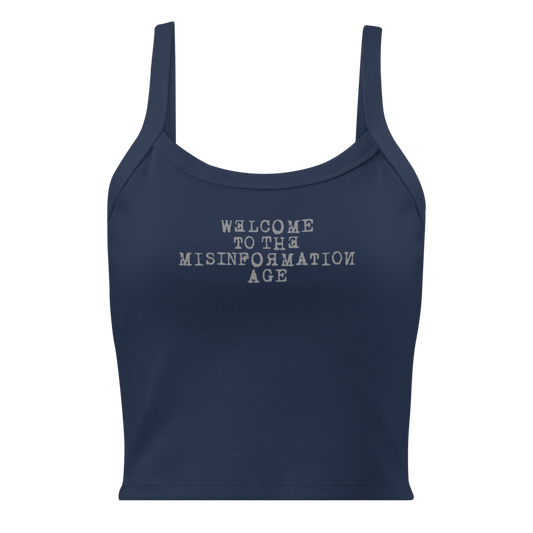 "Welcome to the misinformation age" printed on a solid navy blend women's micro-rib tanktop laying on a flat surface