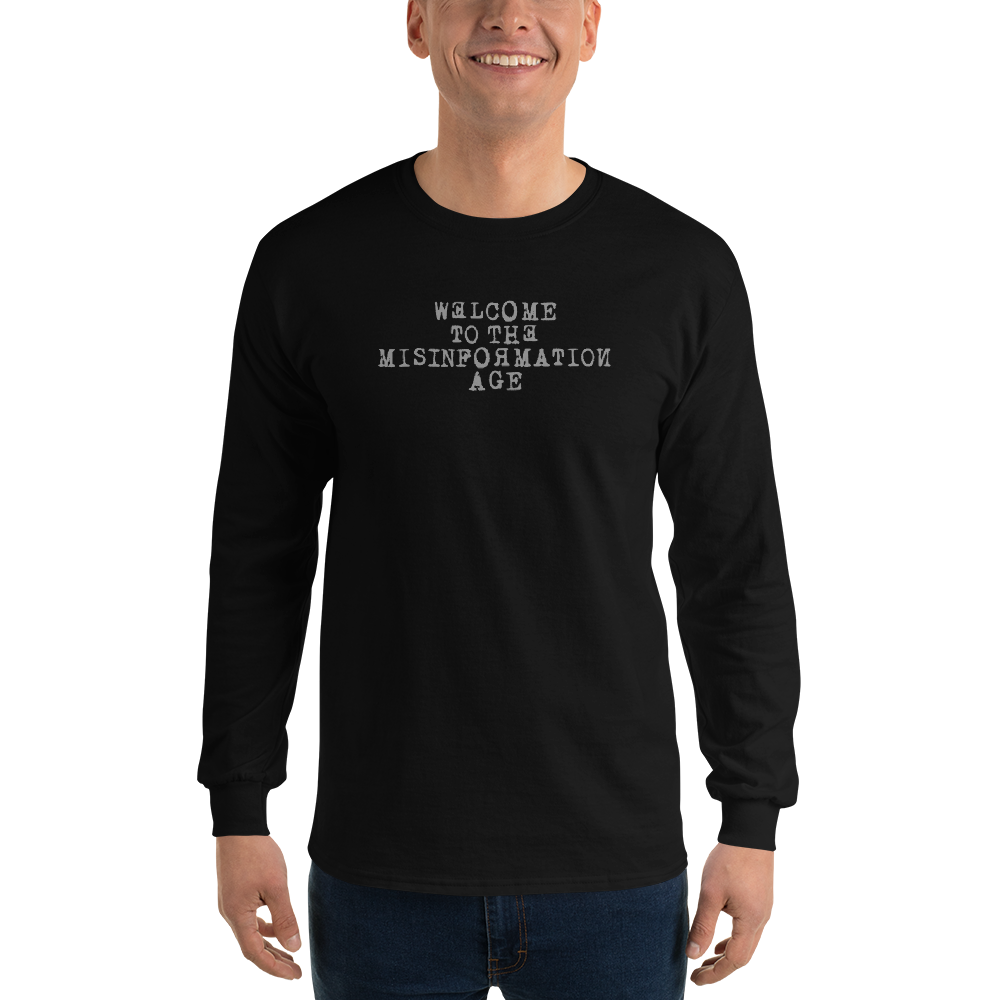 "Welcome to the misinformation age" printed on a black men's long sleeve shirt worn by a male