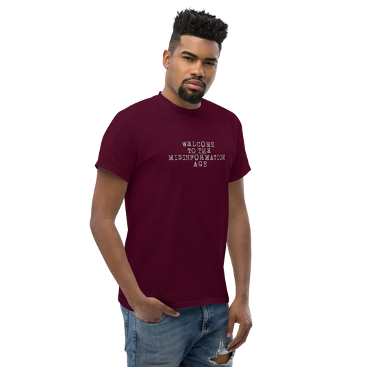 "Welcome to the misinformation age" printed on a maroon unisex classic tee worn by a male