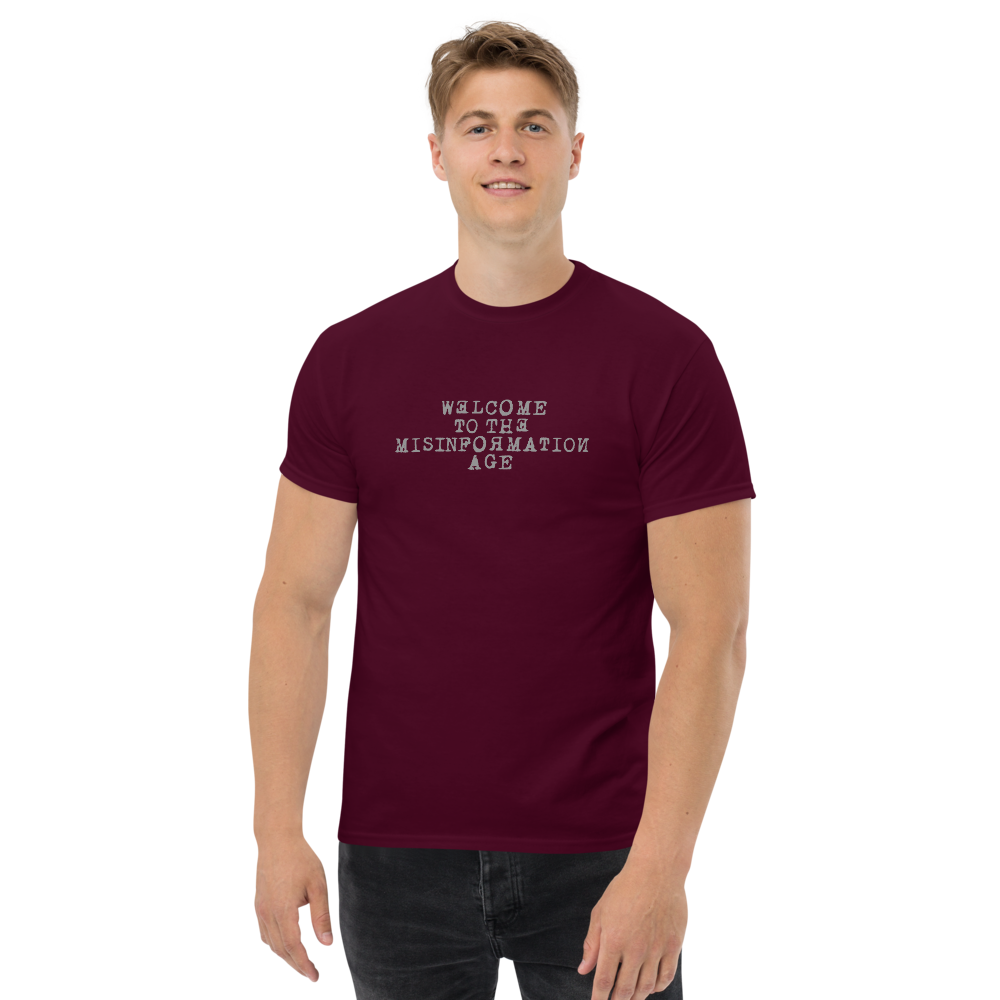 "Welcome to the misinformation age" printed on a maroon unisex classic tee worn by a male