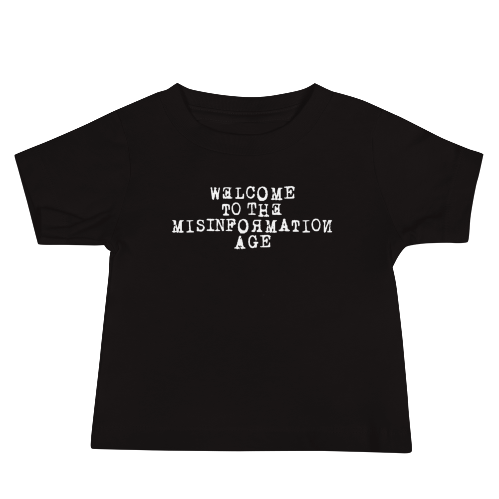 "Welcome to the misinformation age" printed on a black baby jersey short sleeve tee laying on a flat surface