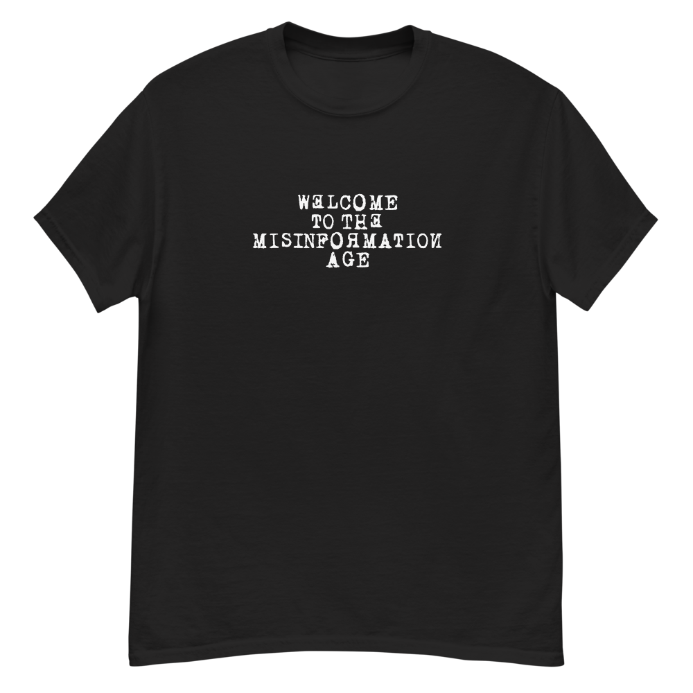 "Welcome to the misinformation age" printed on a black unisex classic tee laying on a flat surface