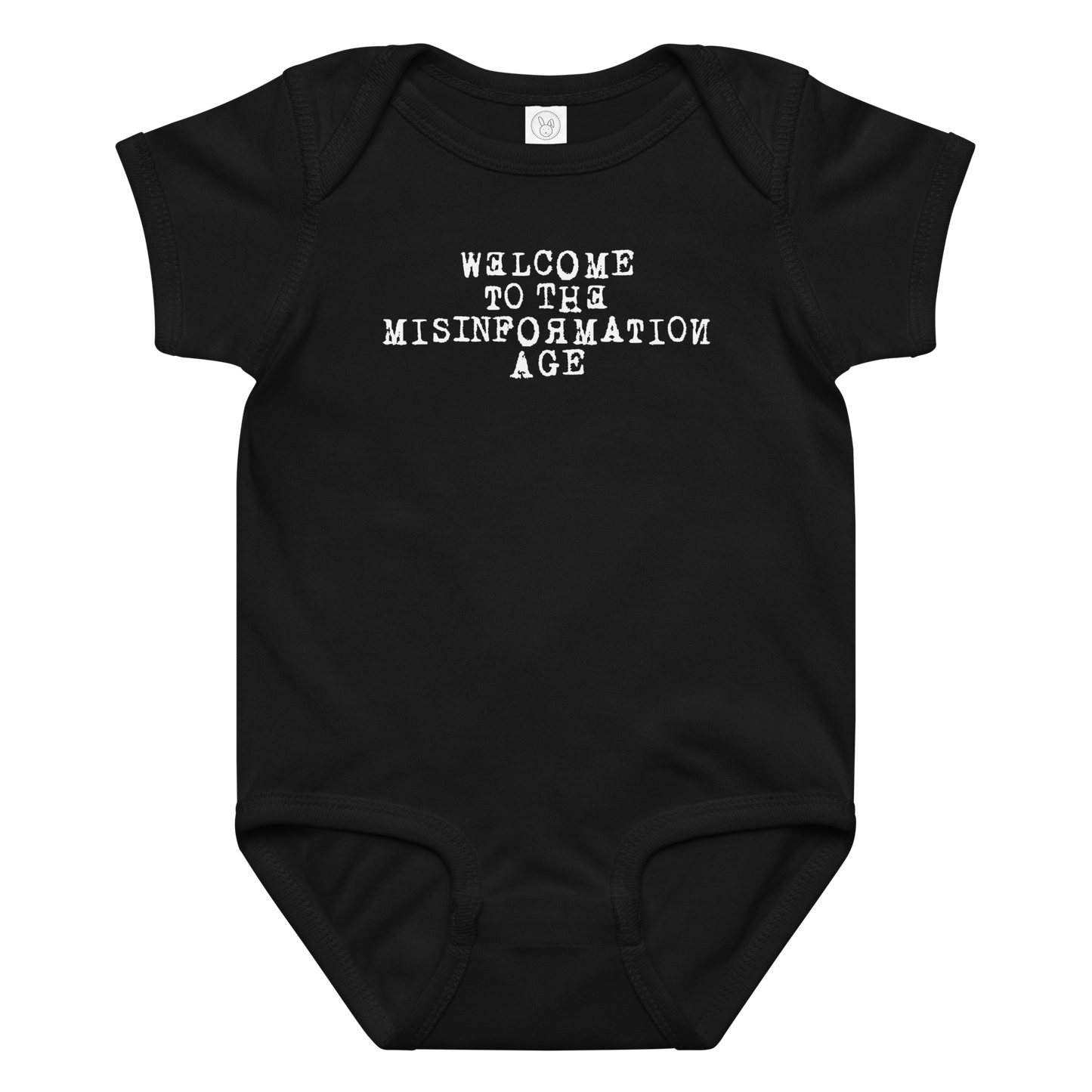 "Welcome to the misinformation age" printed on a black baby jersey bodysuit laying on a flat surface amongst other clothes