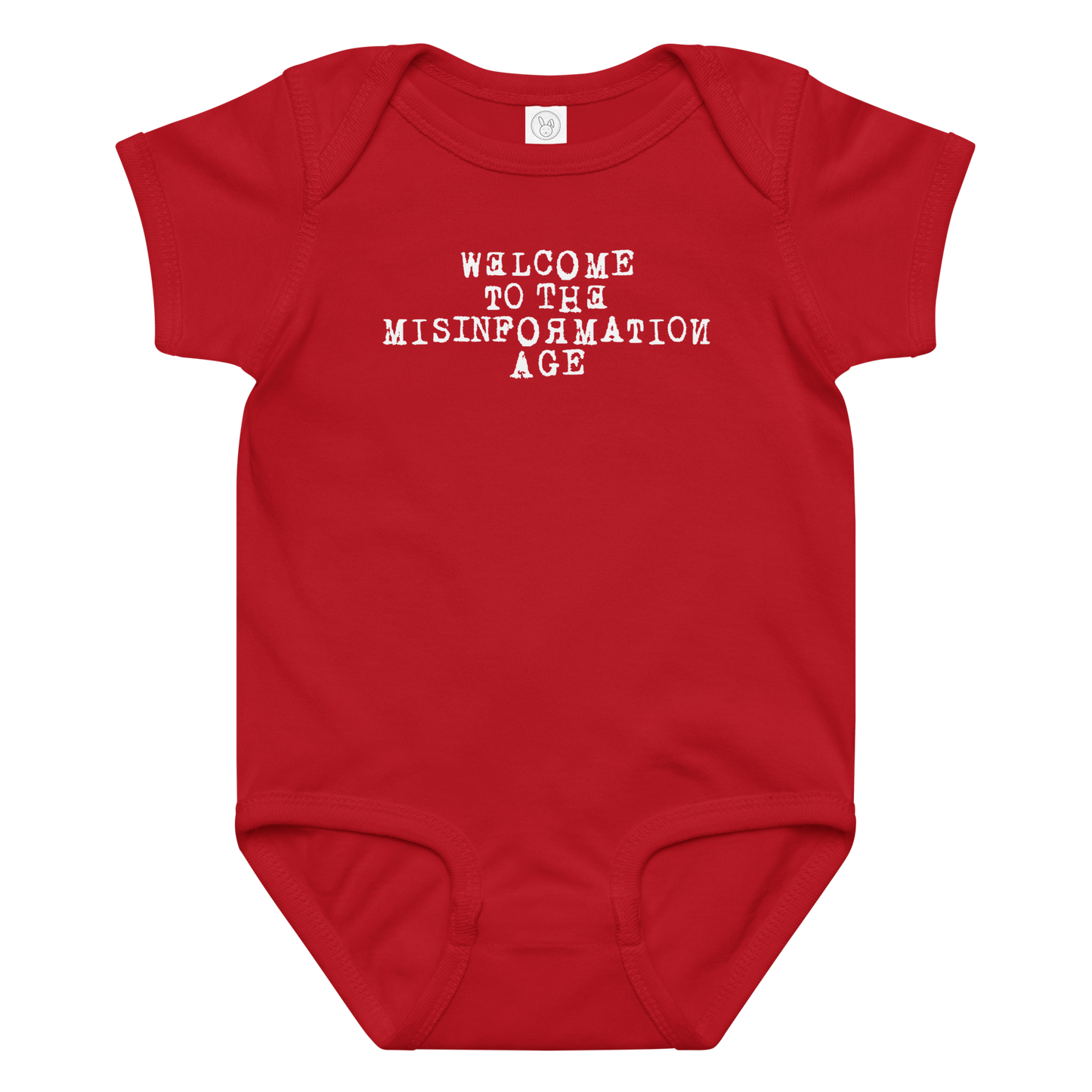 "Welcome to the misinformation age" printed on a red baby jersey bodysuit laying on a flat surface amongst other clothes