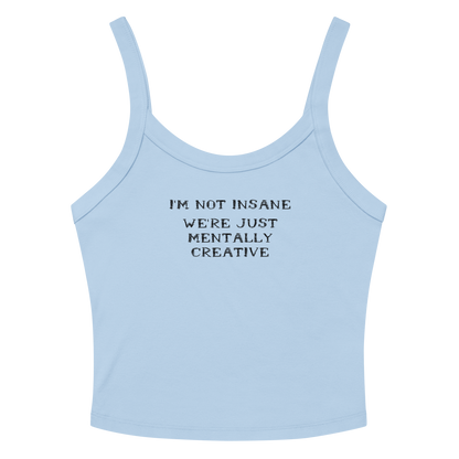 "I’m not insane   We’re just mentally creative" printed on a solid baby blue blend women's micro-rib tanktop laying on a flat surface amongst sunglasses and shorts