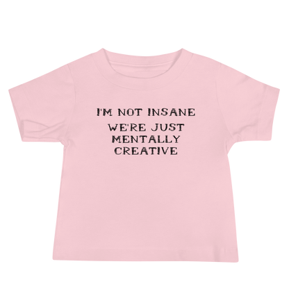 "I’m not insane   We’re just mentally creative" printed on a pink baby jersey short sleeve tee laying on a flat surface