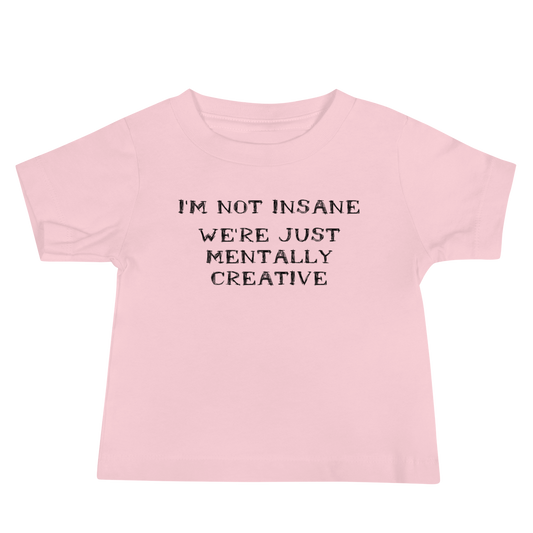 "I’m not insane   We’re just mentally creative" printed on a pink baby jersey short sleeve tee laying on a flat surface