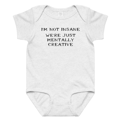 "I’m not insane   We’re just mentally creative" printed on a ash baby jersey bodysuit laying on a flat surface amongst other clothes