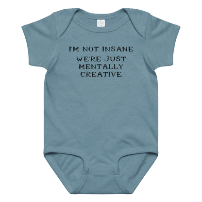 "I’m not insane   We’re just mentally creative" printed on a vintage indigo baby jersey bodysuit laying on a flat surface amongst other clothes