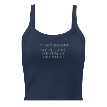 "I’m not insane   We’re just mentally creative" printed on a solid navy blend women's micro-rib tanktop laying on a flat surface