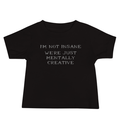 "I’m not insane   We’re just mentally creative" printed on a black baby jersey short sleeve tee laying on a flat surface