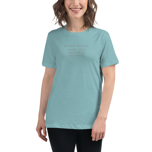 "I’m not insane   We’re just mentally creative" printed on a heather blue lagoon women's relaxed t-shirt worn by a female