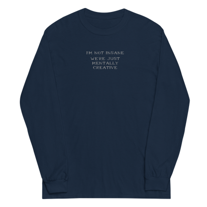 "I’m not insane   We’re just mentally creative" printed on a navy men's long sleeve shirt laying on a flat surface