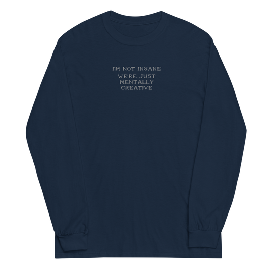 "I’m not insane   We’re just mentally creative" printed on a navy men's long sleeve shirt laying on a flat surface