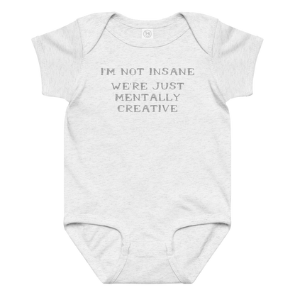 "I’m not insane   We’re just mentally creative" printed on a ash baby jersey bodysuit laying on a flat surface amongst other clothes