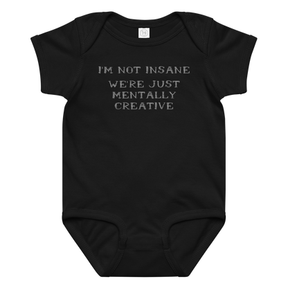 "I’m not insane   We’re just mentally creative" printed on a black baby jersey bodysuit laying on a flat surface amongst other clothes