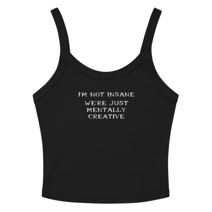"I’m not insane   We’re just mentally creative" printed on a solid black blend women's micro-rib tanktop laying on a flat surface amongst sunglasses and shorts