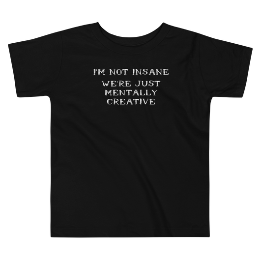 "I’m not insane   We’re just mentally creative" printed on a black toddler short sleeve tee laying on a flat surface
