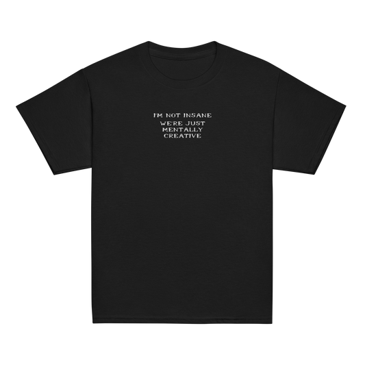 "I’m not insane   We’re just mentally creative" printed on a black youth classic tee laying on a flat surface