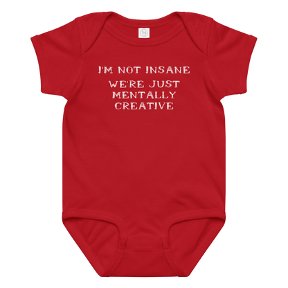 "I’m not insane   We’re just mentally creative" printed on a red baby jersey bodysuit laying on a flat surface amongst other clothes