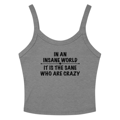 "In an insane world, it is the sane who are crazy" printed on a athletic heather women's micro-rib tanktop laying on a flat surface amongst sunglasses and shorts