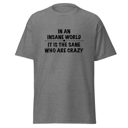 "In an insane world, it is the sane who are crazy" printed on a graphite heather unisex classic tee laying on a flat surface