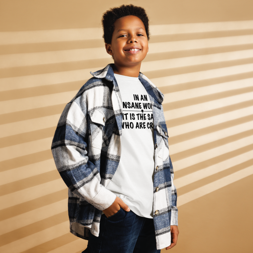 "In an insane world, it is the sane who are crazy" printed on a white youth classic tee worn by a male also wearing a jacket