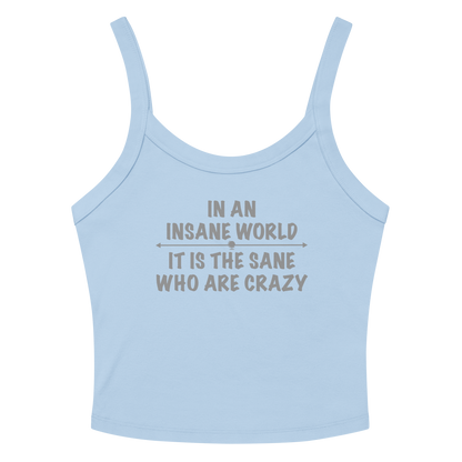 "In an insane world, it is the sane who are crazy" printed on a solid baby blue blend women's micro-rib tanktop laying on a flat surface amongst sunglasses and shorts