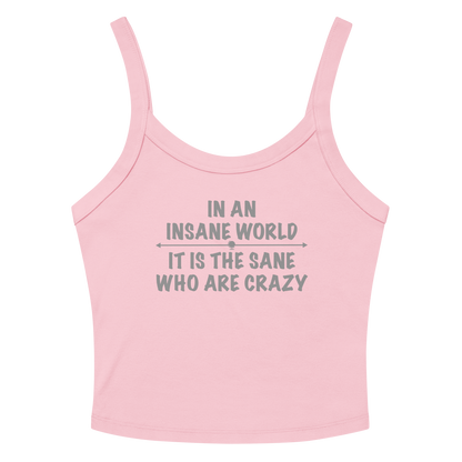"In an insane world, it is the sane who are crazy" printed on a solid pink blend women's micro-rib tanktop laying on a flat surface amongst sunglasses and shorts