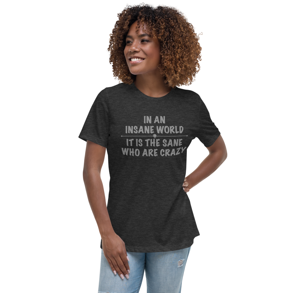 "In an insane world, it is the sane who are crazy" printed on a dark grey heather women's relaxed t-shirt worn by a female