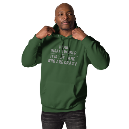 "In an insane world, it is the sane who are crazy" printed on a forest green unisex hoodie worn by a male