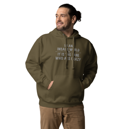 "In an insane world, it is the sane who are crazy" printed on a military green unisex hoodie worn by a male