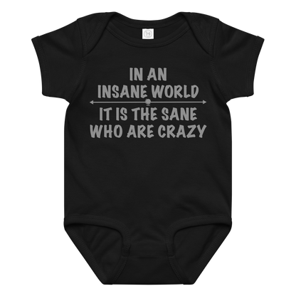 "In an insane world, it is the sane who are crazy" printed on a black baby jersey bodysuit laying on a flat surface amongst other clothes
