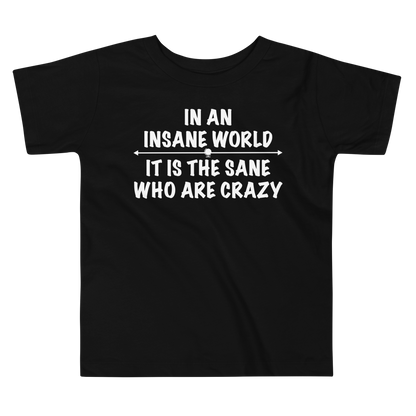 "In an insane world, it is the sane who are crazy" printed on a black toddler short sleeve tee laying on a flat surface