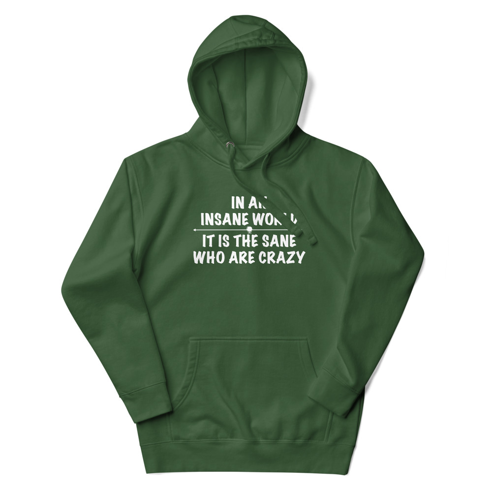 "In an insane world, it is the sane who are crazy" printed on a forest green unisex hoodie laying on a flat surface with the hood up