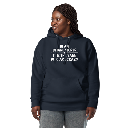 "In an insane world, it is the sane who are crazy" printed on a navy blazer unisex hoodie worn by a female