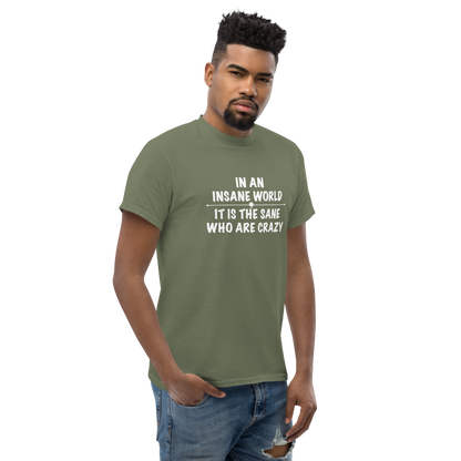 "In an insane world, it is the sane who are crazy" printed on a military green unisex classic tee worn by a male