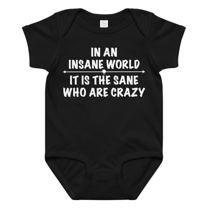 "In an insane world, it is the sane who are crazy" printed on a black baby jersey bodysuit laying on a flat surface amongst other clothes