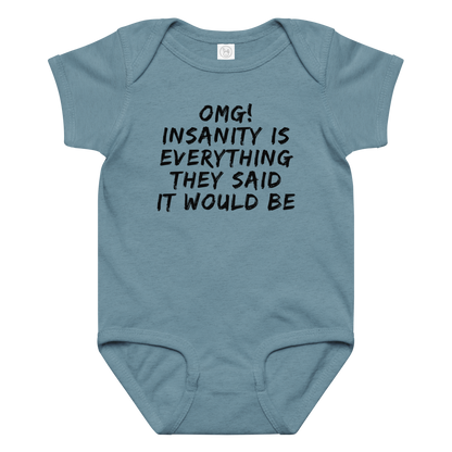 "OMG! Insanity is everything they said it would be" printed on a vintage indigo baby jersey bodysuit laying on a flat surface amongst other clothes