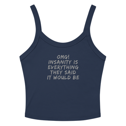 "OMG! Insanity is everything they said it would be" printed on a solid navy blend women's micro-rib tanktop laying on a flat surface amongst sunglasses and shorts
