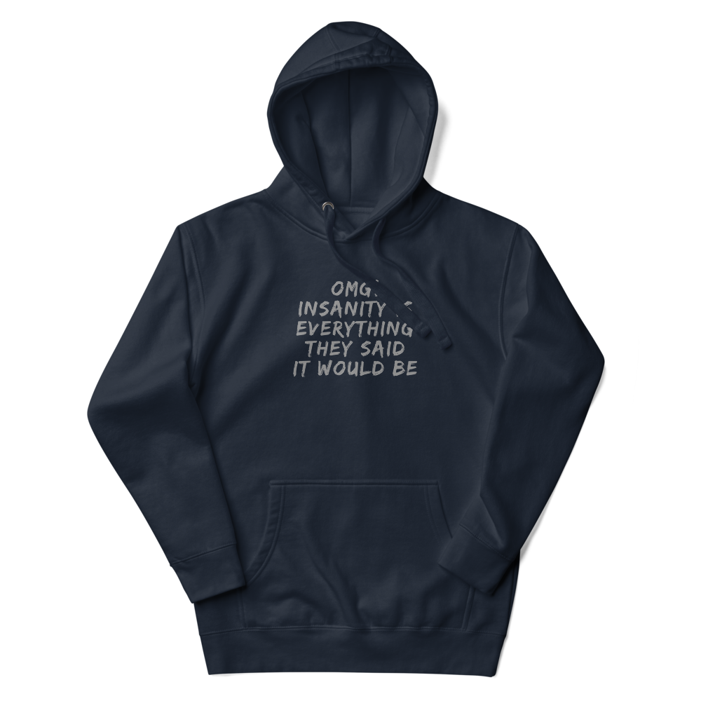"OMG! Insanity is everything they said it would be" printed on a navy blazer unisex hoodie laying on a flat surface with the hood up