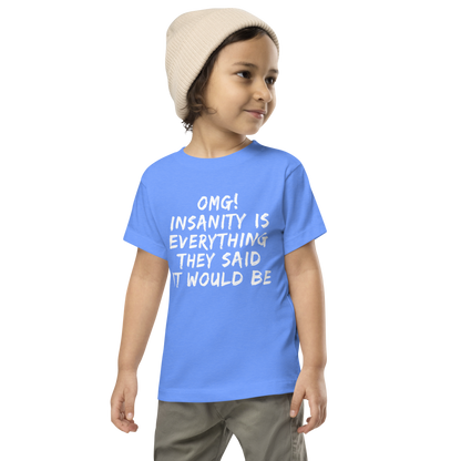 "OMG! Insanity is everything they said it would be" printed on a heather columbia blue toddler short sleeve tee worn by a male wearing a cap