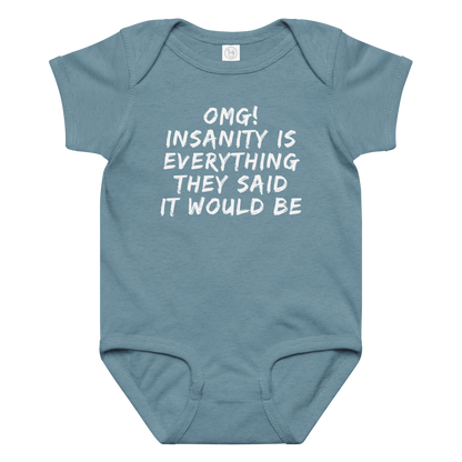 "OMG! Insanity is everything they said it would be" printed on a vintage indigo baby jersey bodysuit laying on a flat surface amongst other clothes