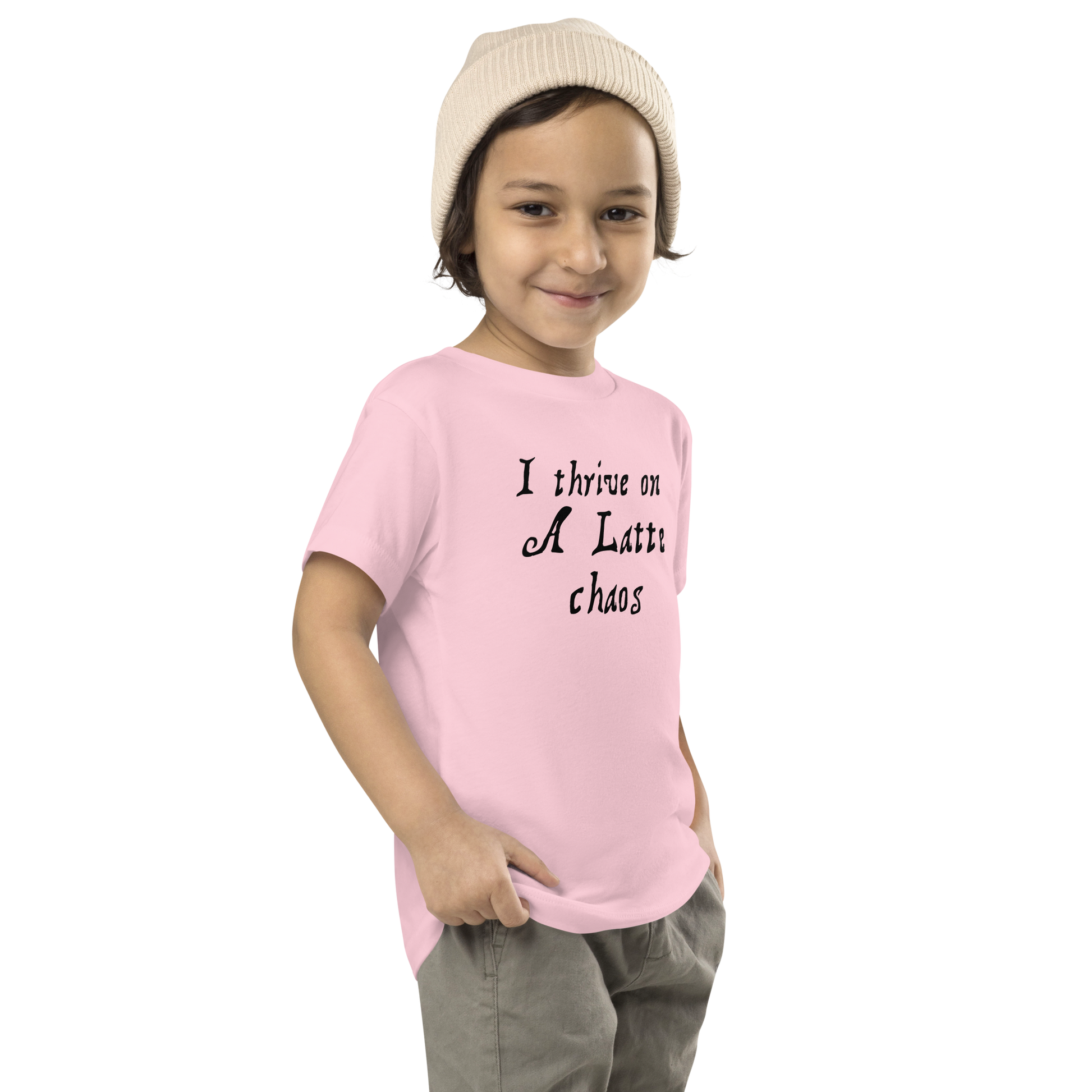 "I thrive on a latte chaos" printed on a pink toddler short sleeve tee worn by a male who is also wearing a knit cap